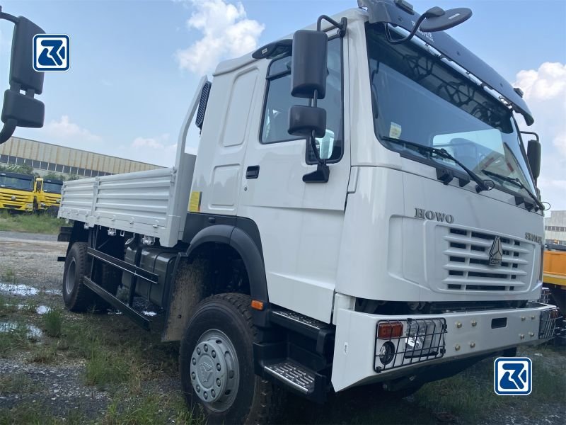 Grande plano da cabina e do chassis dianteiro do camião de carga HOWO 4x4 numa plataforma de transporte