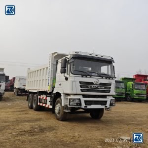 Vista frontal do camião basculante Shacman F3000 6X4 - conjunto frontal robusto e compartimento do motor potente.